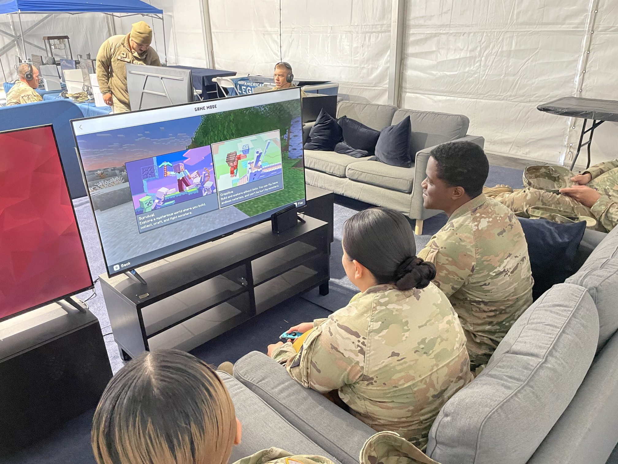 service members playing a video game at ALG booth